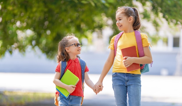 バックパックを持った女の子は学校に行きます