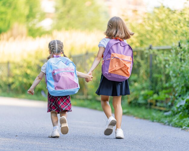 バックパックを持った女の子は学校に行きます