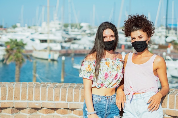 Girls with face mask posing near the harbour