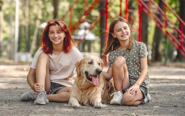 Girls with golden retriever dog