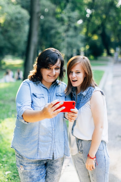 Girls with smartphones talking in the park