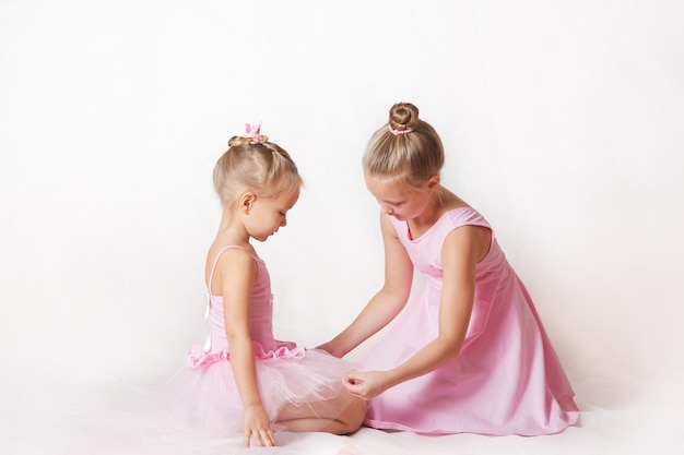 girls  young ballerinas in pink dresses on a light background