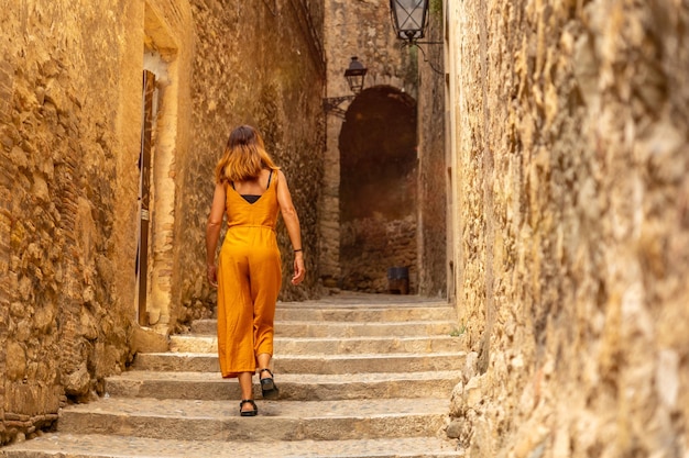 ジローナの中世の街、歴史的な通りを歩く若い観光客