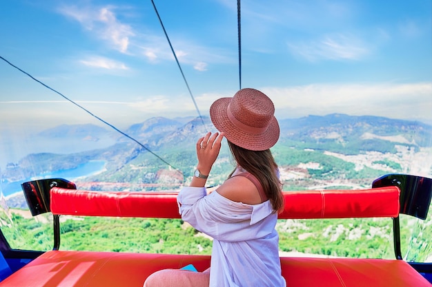 Foto girt viaggiatore turistico seduto nella cabina della funivia durante il viaggio verso punti panoramici in montagna