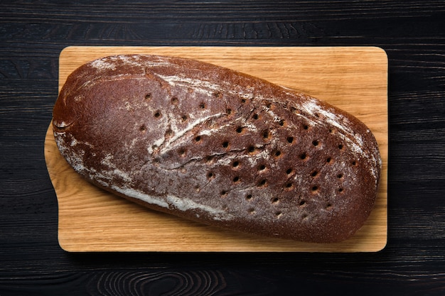 Gistvrij bruin brood op houten snijplank