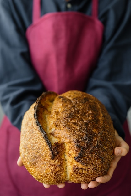 Gistvrij zuurdesembrood een mooie europese bakker houdt brood in haar handen