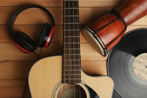 Gitaar met vinylplaten en Afrikaanse drum op houten tafel close-up