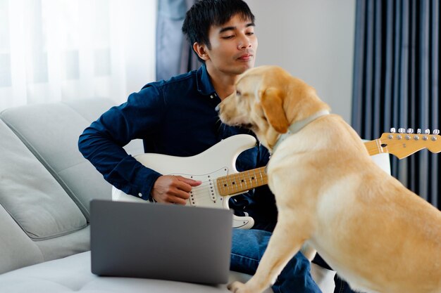 Gitarist die thuis gitaar speelt op de bank Thuis gitaar oefenen Ontspan door snaarinstrumenten te bespelen