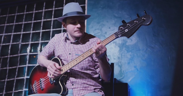 Gitarist met hoed op scène in bar muzikant speelt gitaar