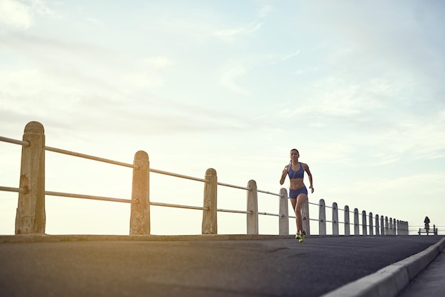 Give it your all and you can have it all shot of a fit young woman out for a run on the promenade