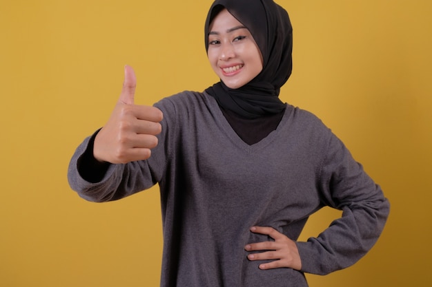 Give thumb of beautiful young woman wearing casual T shirt