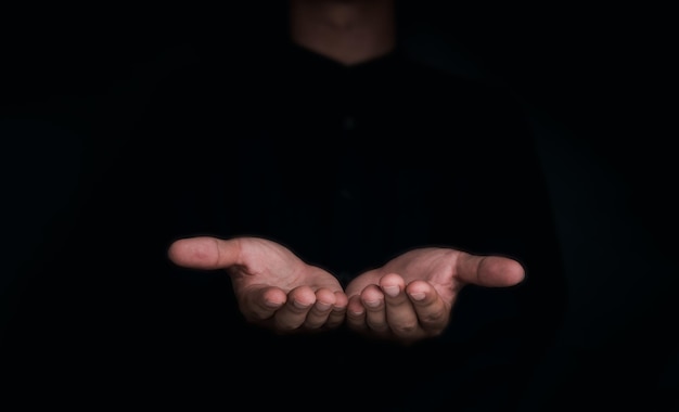 Give two hands with nothing on both on dark background with copy space Closeup receiving gesture of outstretched cupped empty open hands Concept of giving donation receiving asking and bribery