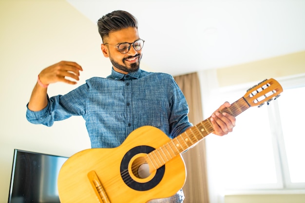 Giving guitar online lessonIndian man is playing the guitar