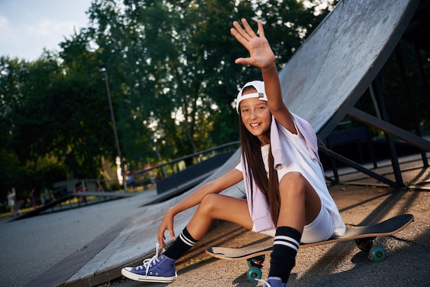 Счастливая девочка на скейтборде на открытом воздухе