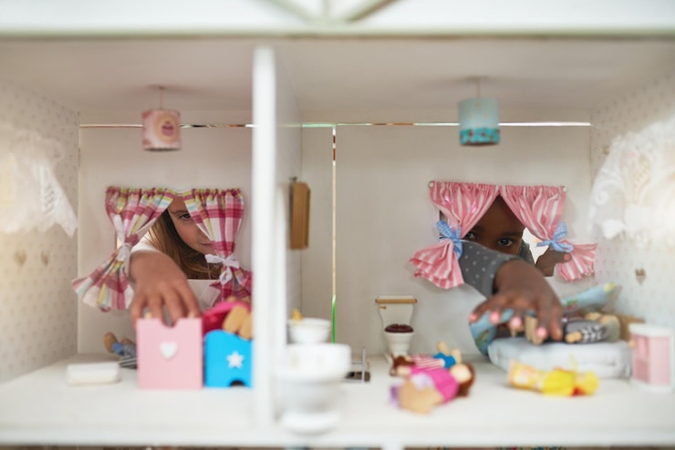 Photo giving their dolls a place to call home cropped shot of two friends playing together with a dollhouse