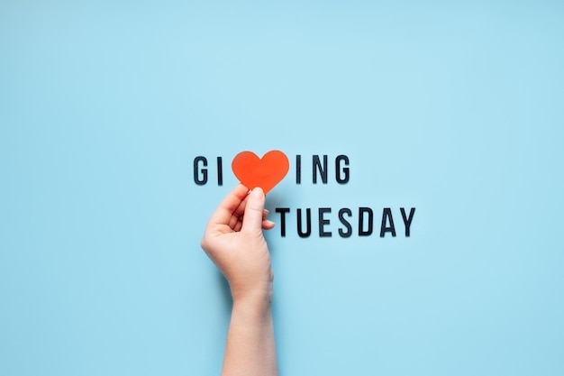 Photo giving tuesday give help donation support volunteer concept with red heart in female hands and text