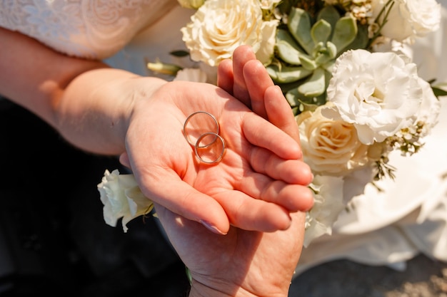 結婚式の花の背景に結婚指輪を与える