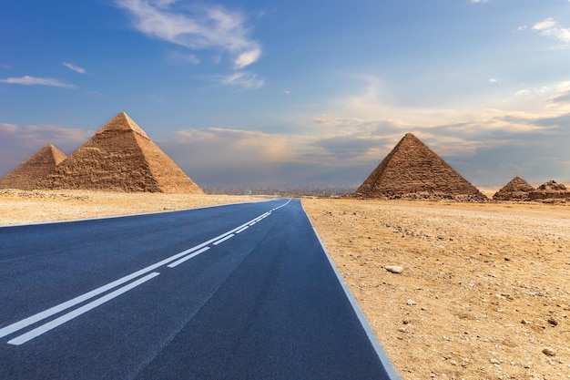 Piramidi di giza e una strada nel deserto, egitto, nessun popolo. Foto Premium