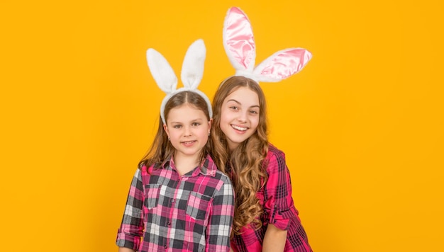 Glad easter children in bunny ears on yellow background