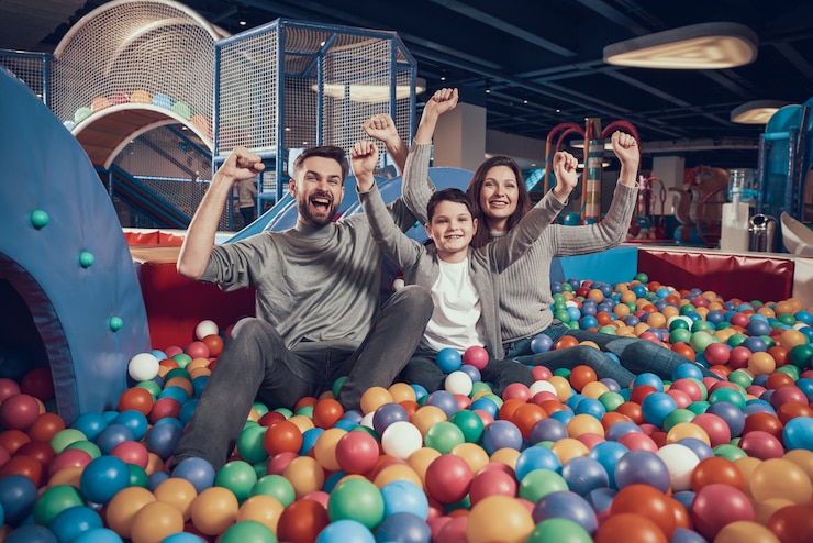 Photo glad family sitting in pool with balls