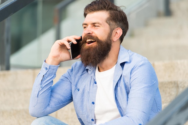 Glad to hear you again. Mobile communication. Mobile conversation. Man with smartphone urban background. Handsome man with phone outdoors. Modern life. Calling friend. Talking concept. Informing.