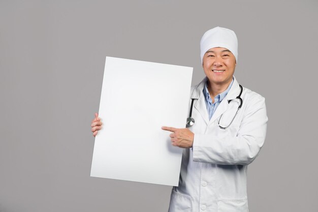 Фото Рад, что зрелый китайский терапевт в белом халате со стетоскопом держит баннер с копией пространства