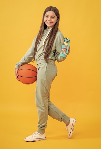 glad teen basketball girl in studio teen basketball girl on background photo of teen basketball girl with water bottle teen basketball girl isolated on yellow