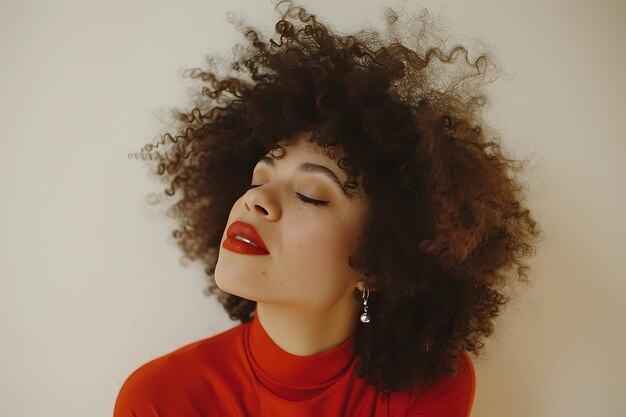 Glad young woman with curly hairstyle standing near light wall