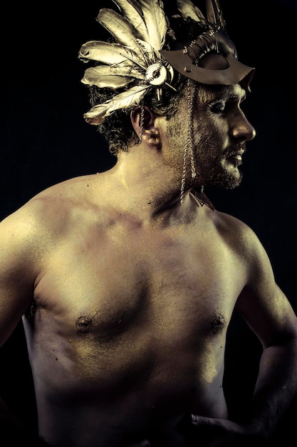 Gladiator, Warrior with helmet and sword with his body painted gold dust