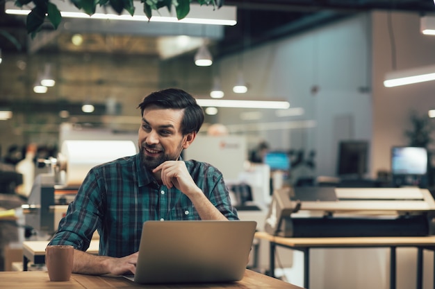 Gladsome young office worker sitting at his workplace and\
turning head. website banner