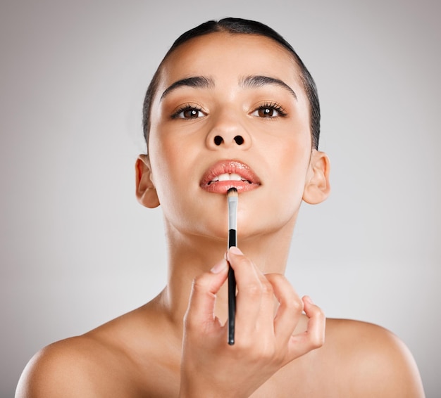 Glam is my go to look Studio shot of an attractive young woman applying lipstick against a grey background