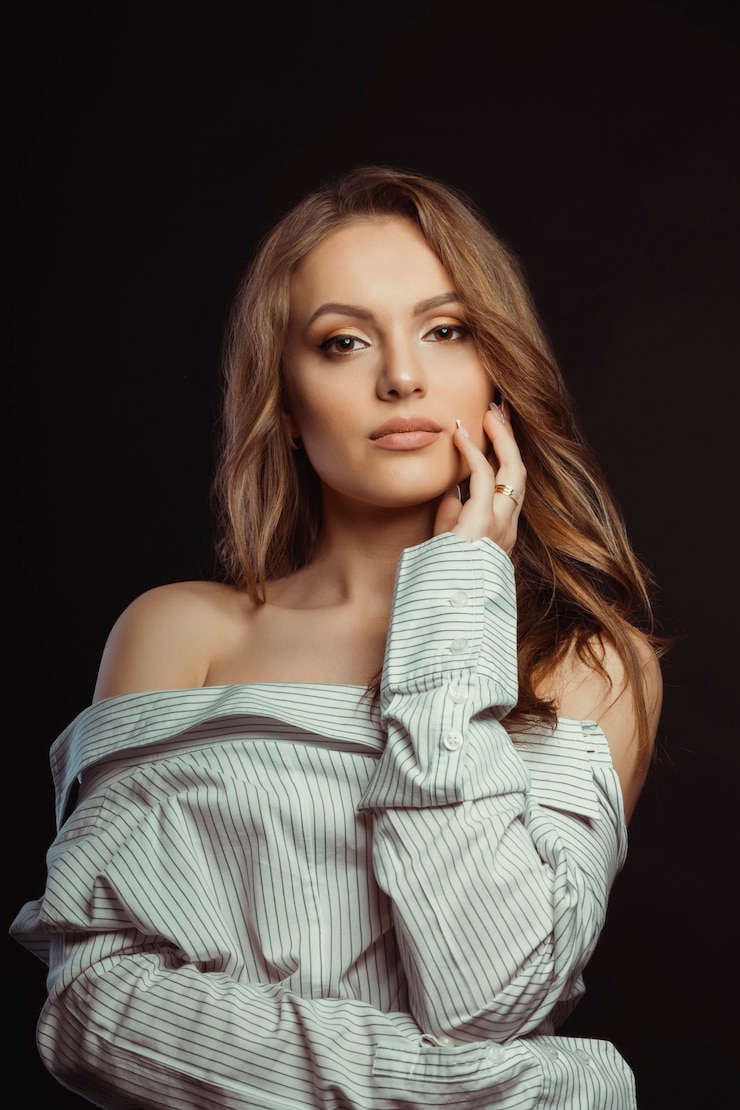 Photo glamor brunette woman posing in men's shirt on a black background