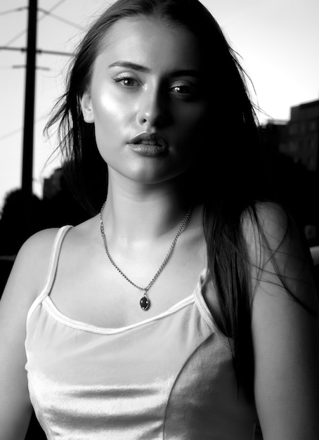 Glamor young woman dressed in a casual clothes walking at the city. Black and white closeup shot
