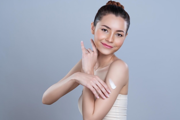 Glamorous beautiful woman applying moisturizer cream on her arm for perfect skin