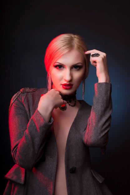 Glamorous blonde woman with bright makeup and red light