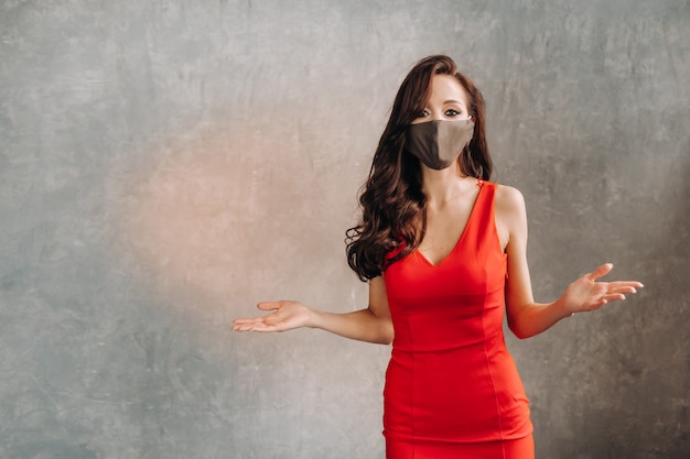 Glamorous girl in a red dress and a protective mask on a vintage.