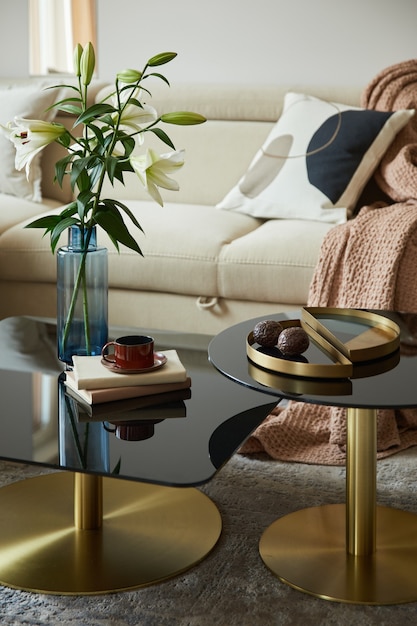 モダンなベージュのソファ、ガラスのコーヒーテーブル、金色のアクセサリーを備えた華やかなリビングルームのインテリアデザイン。細部の美しさ。レンプレート。