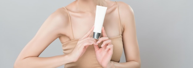 Glamorous perfect skin woman holding mockup moisturizer tube
