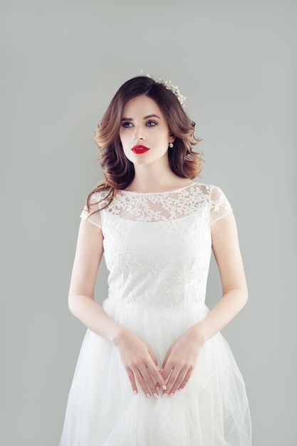 Sposa affascinante della donna nel ritratto dello studio del vestito bianco