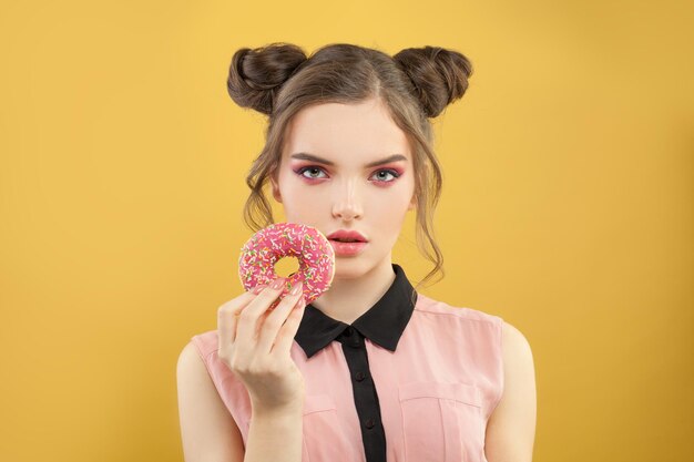 Photo glamorous woman and donut on yellow background