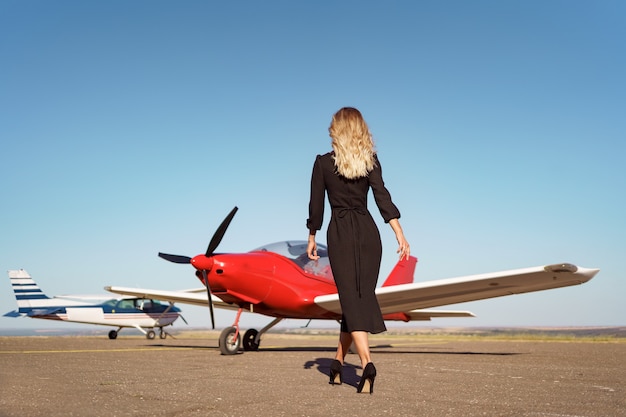 Foto donna affascinante che posa sull'aereo