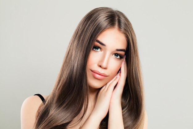 Donna affascinante con capelli castani naturali e pelle perfetta. bellissima modella con lunghi capelli sani