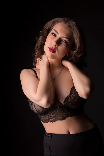 Glamour jong model in zwarte kanten lingerie in de schaduw