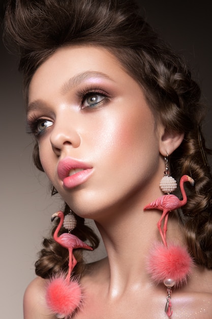 Glamour portrait of beautiful girl model with makeup and romantic hairstyle.