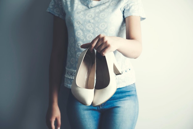 여성의 손에 매력적인 신발 흰색 가죽