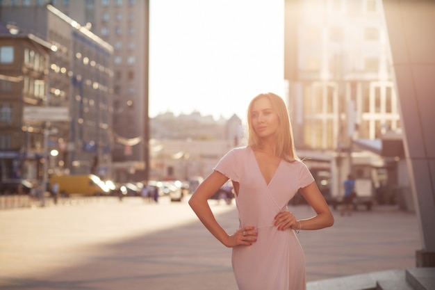 Glamoureuze blonde model poseren op straat in zonnestraal. Levensstijl mode concept. Ruimte voor tekst