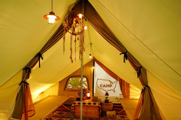 Глэмпинг в палатке в теплом желтом свете.