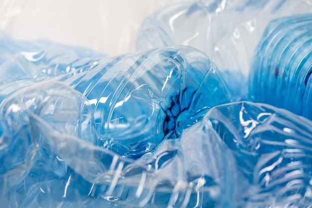 Glancing clear big size water bottles placed in an unwanted heap of unprocessed trash