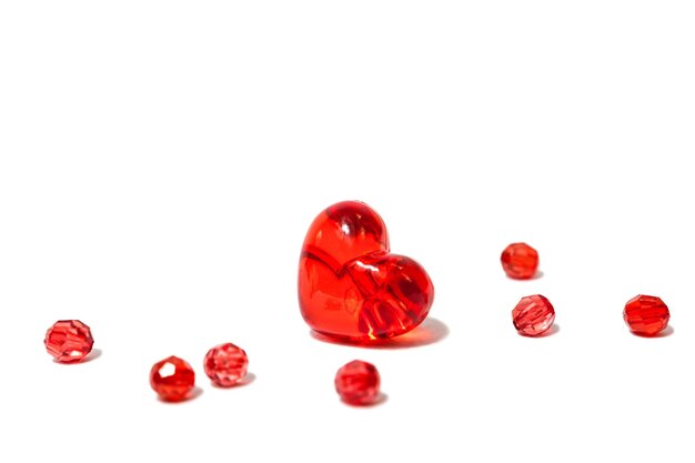 Glanzend rood glazen hart met kralen geïsoleerd op de witte achtergrond - liefdesymbool of trouwkaart