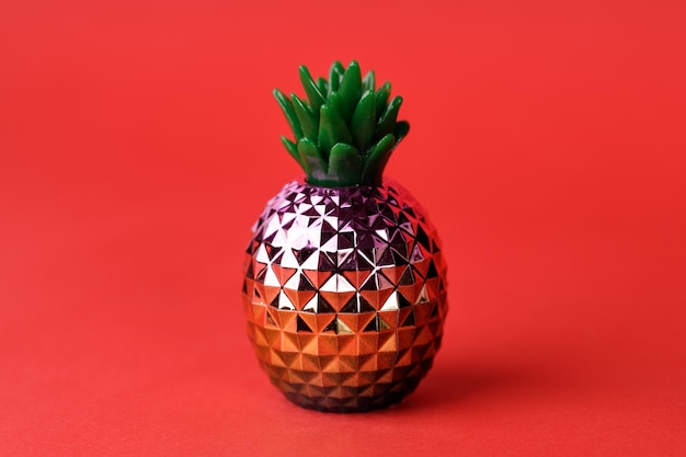 Glanzende decoratieve ananas op rode achtergrond